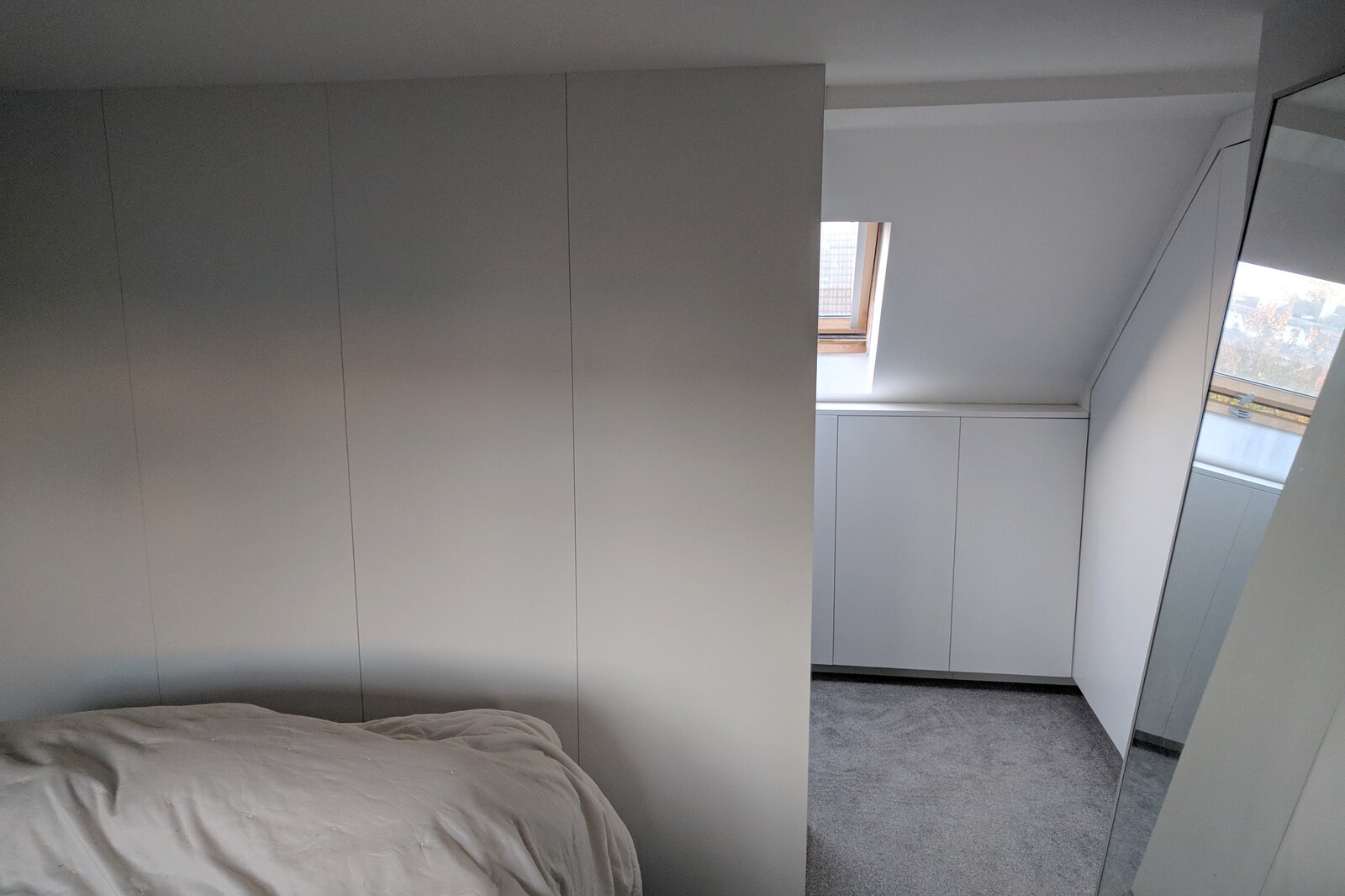 A walk-in loft storage area designed, built and installed by Cook Joinery, London.